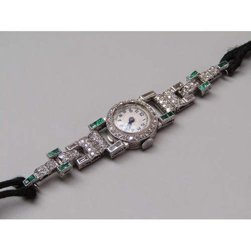 94 - An early 20c platinum, diamond and emerald set ladies wristwatch with a seventeen jewel movement.