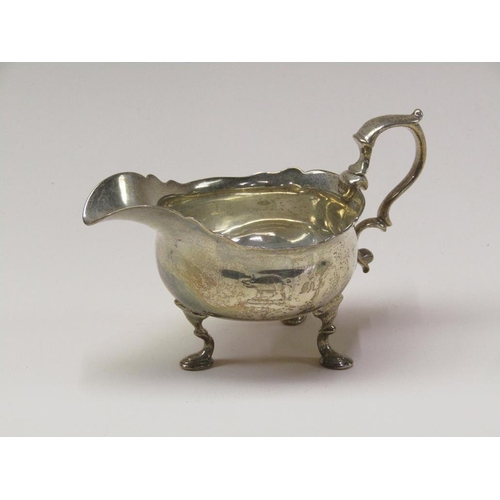 140 - A George III silver sauce boat with double scroll handle, supported on three legs with hoof feet, Lo... 