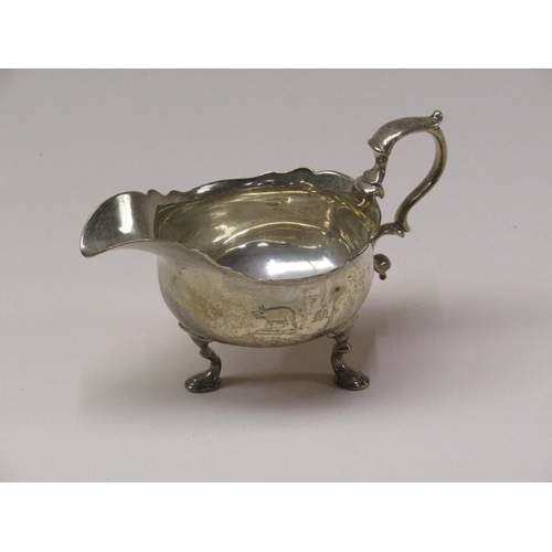 140 - A George III silver sauce boat with double scroll handle, supported on three legs with hoof feet, Lo... 