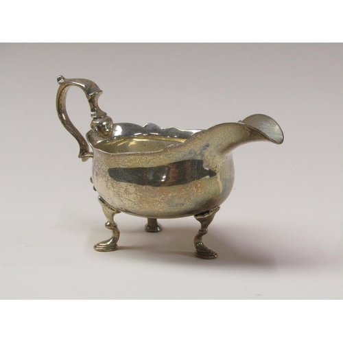 140 - A George III silver sauce boat with double scroll handle, supported on three legs with hoof feet, Lo... 