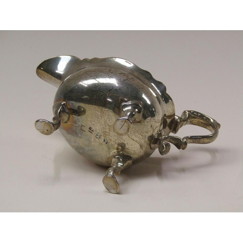 140 - A George III silver sauce boat with double scroll handle, supported on three legs with hoof feet, Lo... 