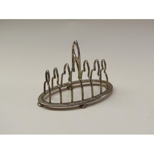 152 - A late Victorian six division silver toast rack of oval engraved form with a central carrying handle... 