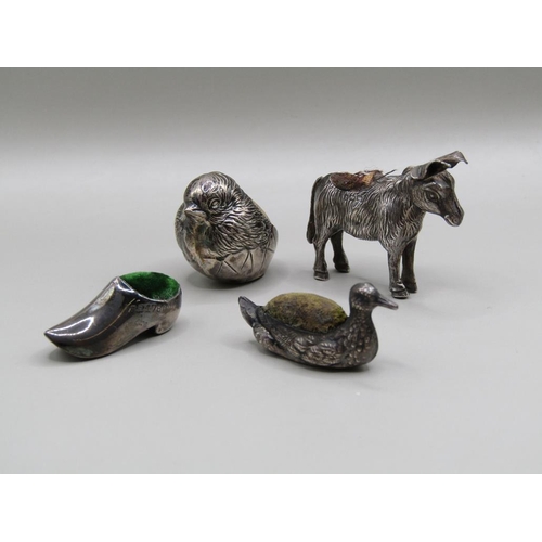 113 - Four silver miniature pin cushions comprising a donkey, Birmingham 1909, a baby bird, Chester 1907, ... 