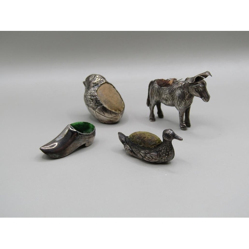 113 - Four silver miniature pin cushions comprising a donkey, Birmingham 1909, a baby bird, Chester 1907, ... 