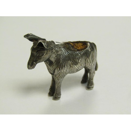 113 - Four silver miniature pin cushions comprising a donkey, Birmingham 1909, a baby bird, Chester 1907, ... 