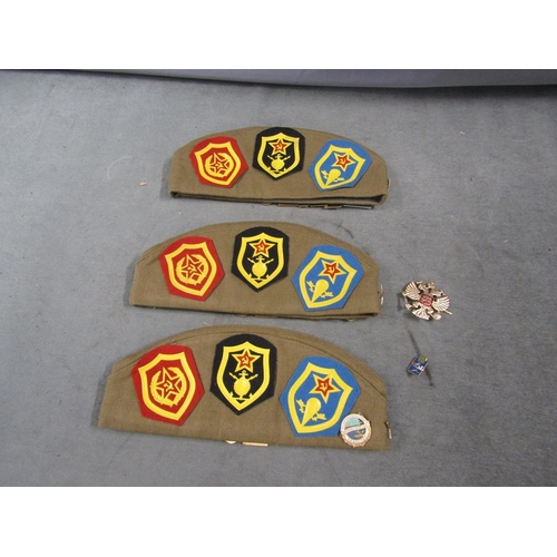 1323 - THREE RUSSIAN CAPS - ALL WITH BADGES, 28CM W