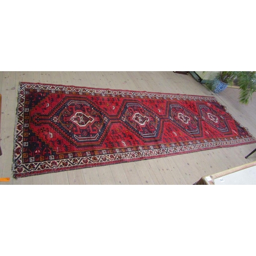 2095 - ORIENTAL WOOLLEN RED GROUND RUG, 128CM X 374CM