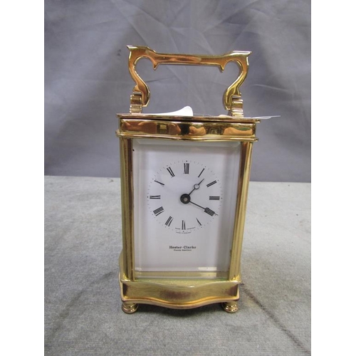 1426 - BRASS CASED CARRIAGE CLOCK BY HESTER CLARK - 16.5cms H WITH THE HANDLE RAISED