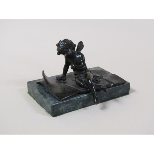 29 - A late 19c/early 20c patinated bronzed figure of a cherub seated no a rug, in the manner of and insc... 