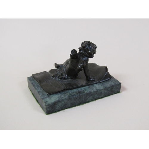 29 - A late 19c/early 20c patinated bronzed figure of a cherub seated no a rug, in the manner of and insc... 