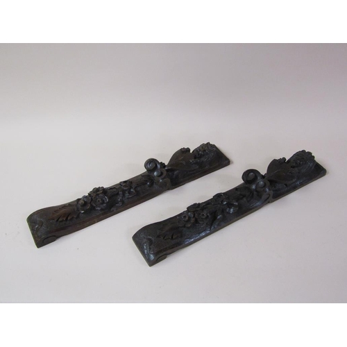 57 - A pair of 19c oak furniture mounts carved with lion and shield, over suspended bow and flowers, each... 