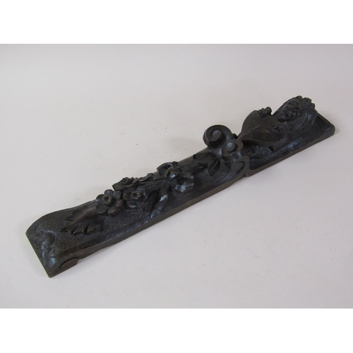 57 - A pair of 19c oak furniture mounts carved with lion and shield, over suspended bow and flowers, each... 