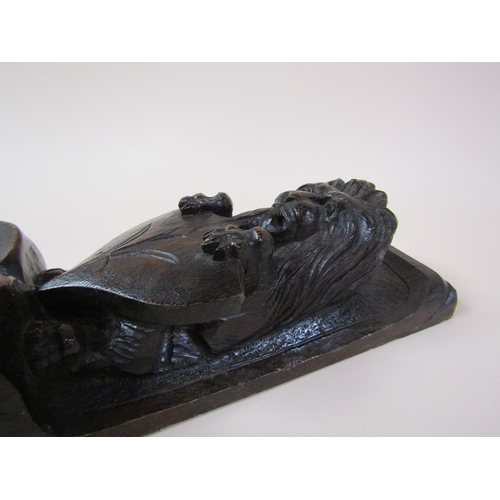 57 - A pair of 19c oak furniture mounts carved with lion and shield, over suspended bow and flowers, each... 