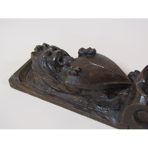 57 - A pair of 19c oak furniture mounts carved with lion and shield, over suspended bow and flowers, each... 