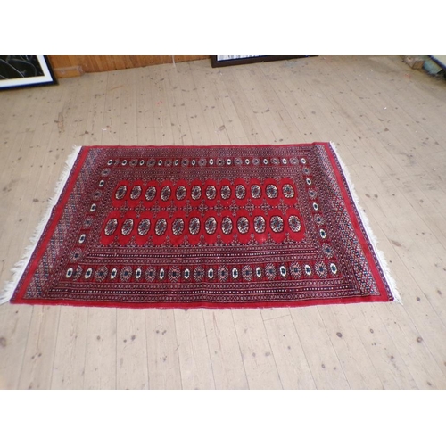 1973 - ORIENTAL RED GROUND PATTERNED RUG, 124cm x 197cm