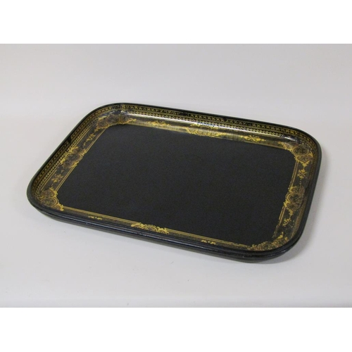 67 - A black lacquered papier mache tea tray of rectangular form with a raised border, gilt decorated, 62... 