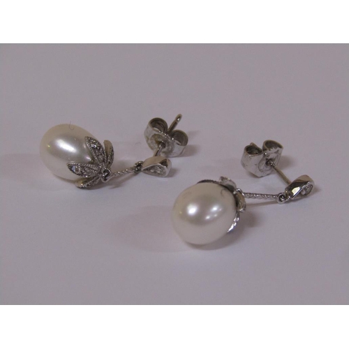 120 - A pair of 18ct white gold diamond and pearl drop earrings.