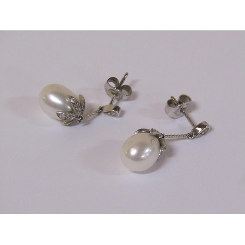 120 - A pair of 18ct white gold diamond and pearl drop earrings.