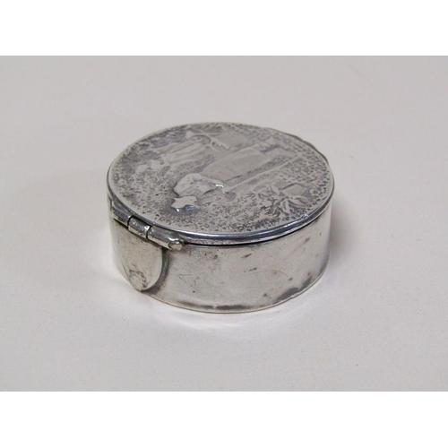 130 - A 19c silver circular box with hinge cover, the cover embossed and chased with the scene of a garden... 