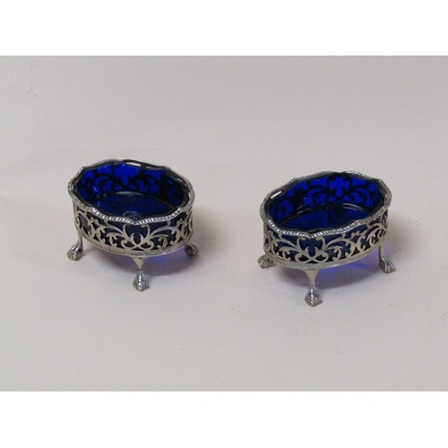 137 - A pair of mid Georgian silver table salts of pierced oval form with ball and claw feet, blue glass l... 