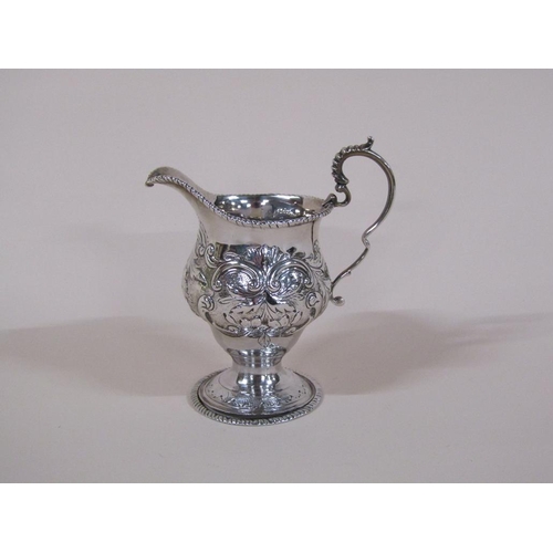 139 - A late 18c/early 19c silver cream jug, embossed and chased with beaded upper rim and base, having do... 