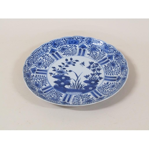 172 - A Chinese blue and white plate decorated with flowers and blossom with a central circular panel, fou... 