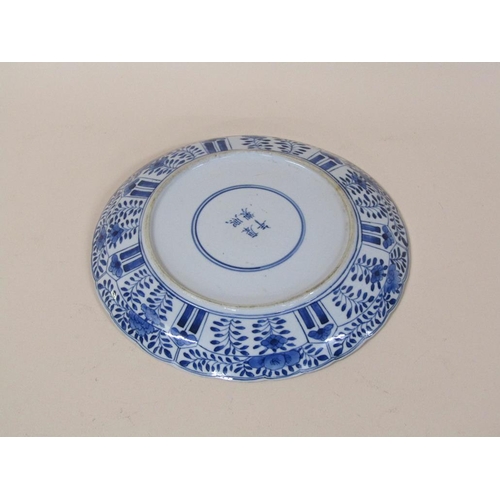 172 - A Chinese blue and white plate decorated with flowers and blossom with a central circular panel, fou... 