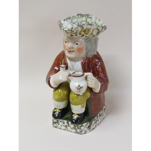 179 - A 19c Staffordshire toby jug, the base and rim dappled wearing a brown coat and yellow trousers, 27c... 