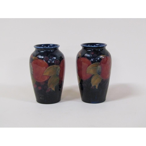 193 - A pair of early 20c Moorcroft Pomegranate vases of baluster form, decorated on a blue ground, painte... 