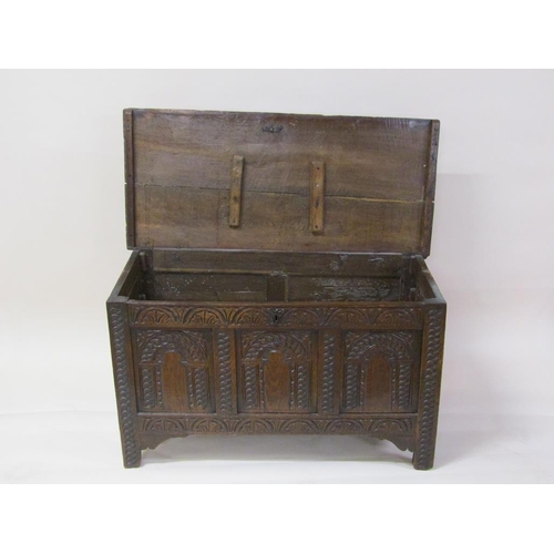 265 - A late 18c/early 19c oak three panel coffer with profusely carved panels and frieze, wire hinged cov... 