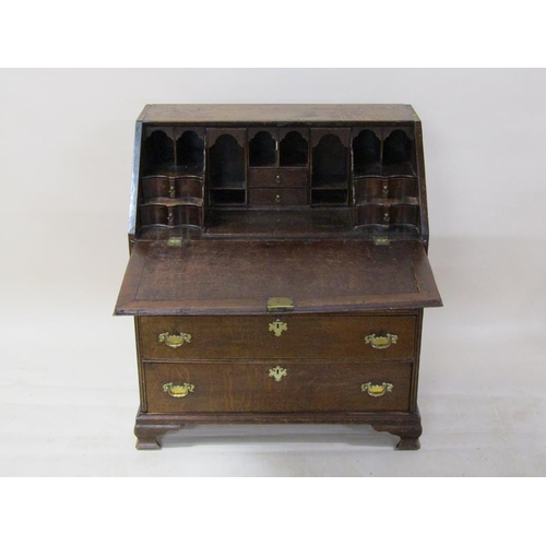 268 - A George III oak bureau with fall front and fitted interior with well, over three short and two long... 