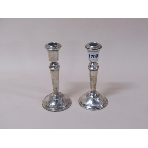 1709 - PAIR OF SILVER CASED FILLED CANDLESTICKS