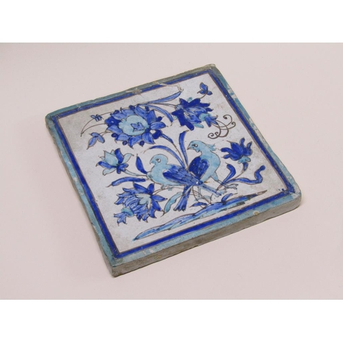 174 - An 18c/19c style Persian large tile decorated in shades of blue with flowers and birds, 19.5cm sq.