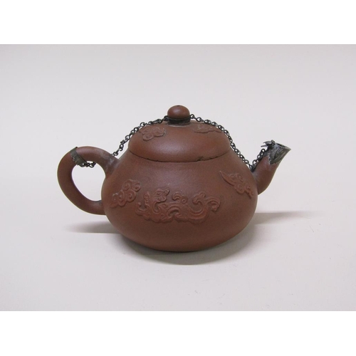 179 - A early Chinese terracotta teapot decorated in relief with flowers, with metal chain and spout, 10cm... 