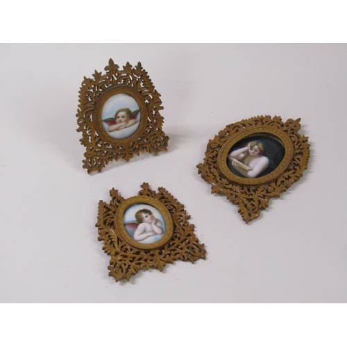 66 - Three 19c oval porcelain plaques, two of cherubs, 6cm x 5cm, and one of a lady reading a book, 8cm x... 