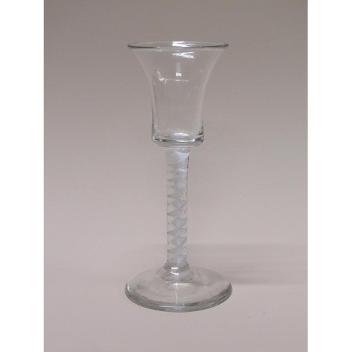 153 - An 18c wine glass with a bell bowl on an opaque white twist stem with a domed circular foot, 15cm h.