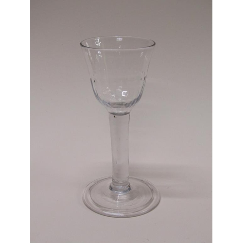 154 - An 18c wine glass with a bell shaped half facet moulded bowl on a clear glass stem with a folded, sl... 