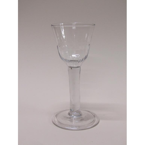 154 - An 18c wine glass with a bell shaped half facet moulded bowl on a clear glass stem with a folded, sl... 