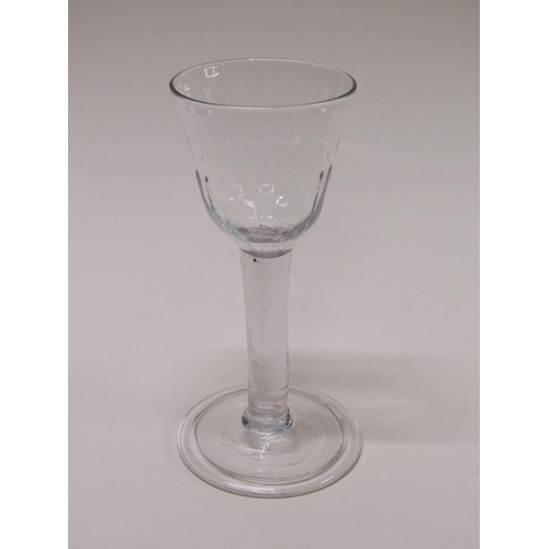 154 - An 18c wine glass with a bell shaped half facet moulded bowl on a clear glass stem with a folded, sl... 