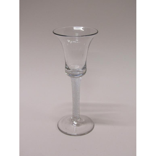 160 - An 18c wine glass with a bell shaped bowl on a stem with three spiral tapes outside gauze on a circu... 