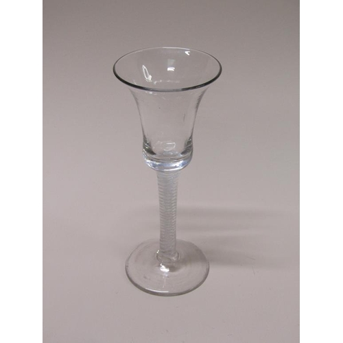 160 - An 18c wine glass with a bell shaped bowl on a stem with three spiral tapes outside gauze on a circu... 