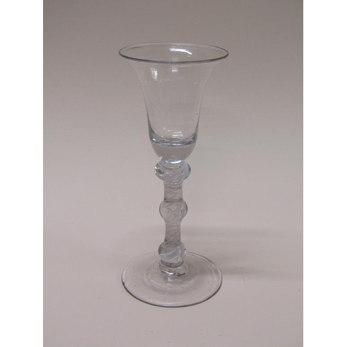 162 - An 18c wine glass with a bell shaped bowl on a triple knopped stem with spiral thread surrounding ga... 