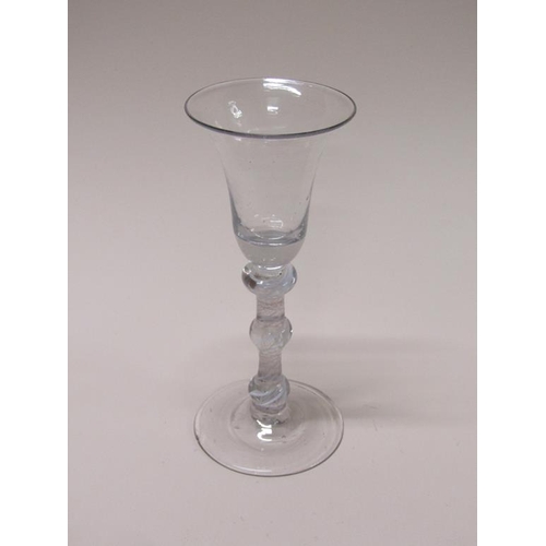 162 - An 18c wine glass with a bell shaped bowl on a triple knopped stem with spiral thread surrounding ga... 