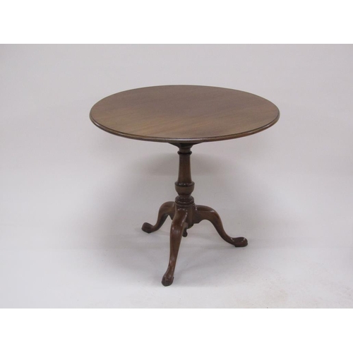 273 - A late Georgian mahogany circular pedestal tilt top table with a baluster carved column raised by th... 