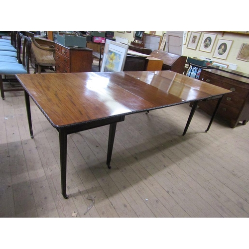 275 - An early 19c mahogany wind out dining table with three extra leaves, the table edge and leaves carve... 