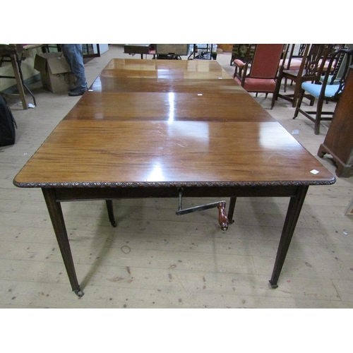 275 - An early 19c mahogany wind out dining table with three extra leaves, the table edge and leaves carve... 