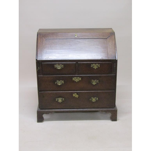 302 - A late Georgian oak bureau with fall front and fitted interior, over two short and two long drawers,... 