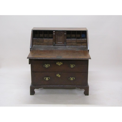 302 - A late Georgian oak bureau with fall front and fitted interior, over two short and two long drawers,... 