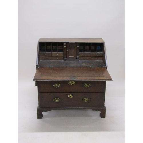 302 - A late Georgian oak bureau with fall front and fitted interior, over two short and two long drawers,... 