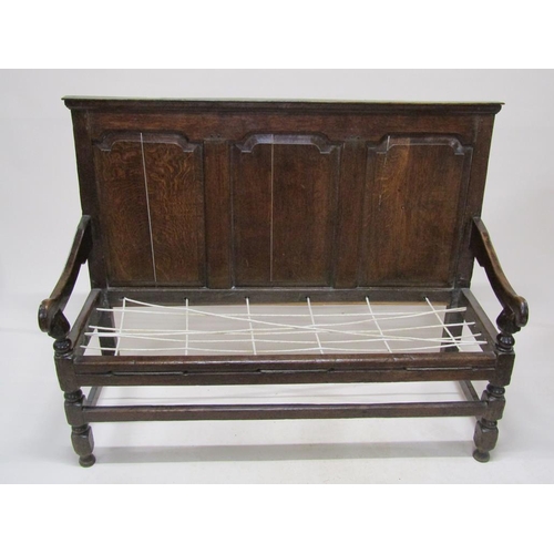 304 - An 18c oak three panel back settle with scrolling arms, on block carved legs with front stretcher ra... 